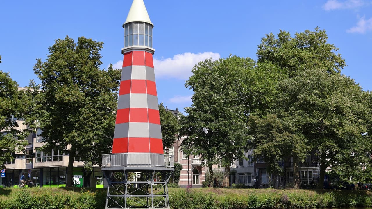 De Academiesingel in Breda met het water, bomen en de rood-witte vuurtoren gezien vanaf Park Valkenberg.