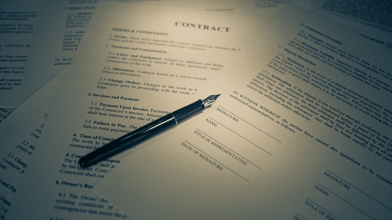 Een contract op tafel met een pen erop.