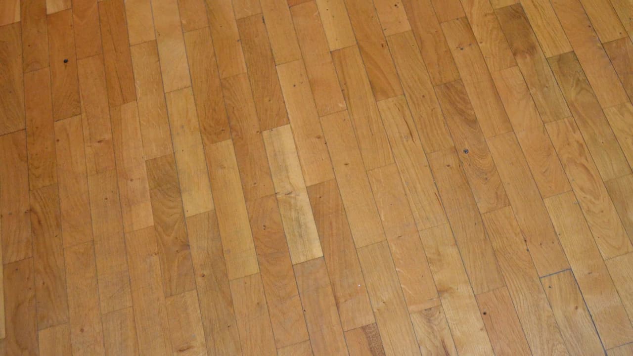 Een houten vloer van smalle planken in verschillende tinten.